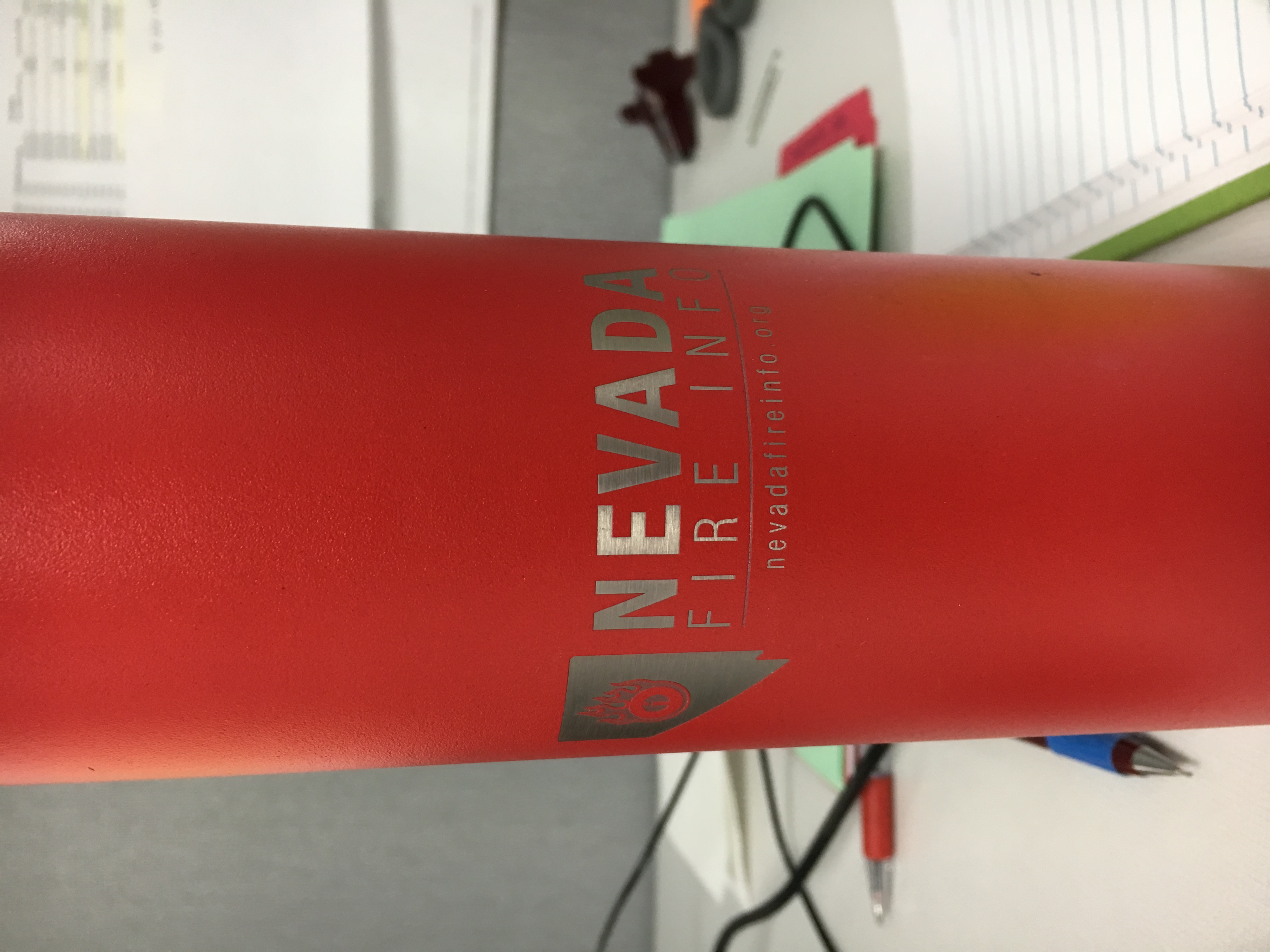 Photo of a red water bottle with the logo etched into the coating of the bottle
