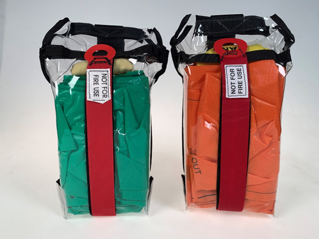 Two practice shelters in clear carriers placed side by side, one green, the other orange, labeled: Not For Fire Use.