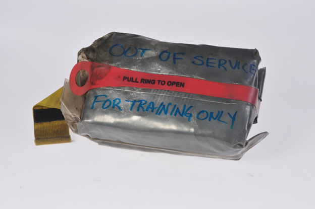 A metallic shelter in a clear bag with label: Out of Service For Training Only. 