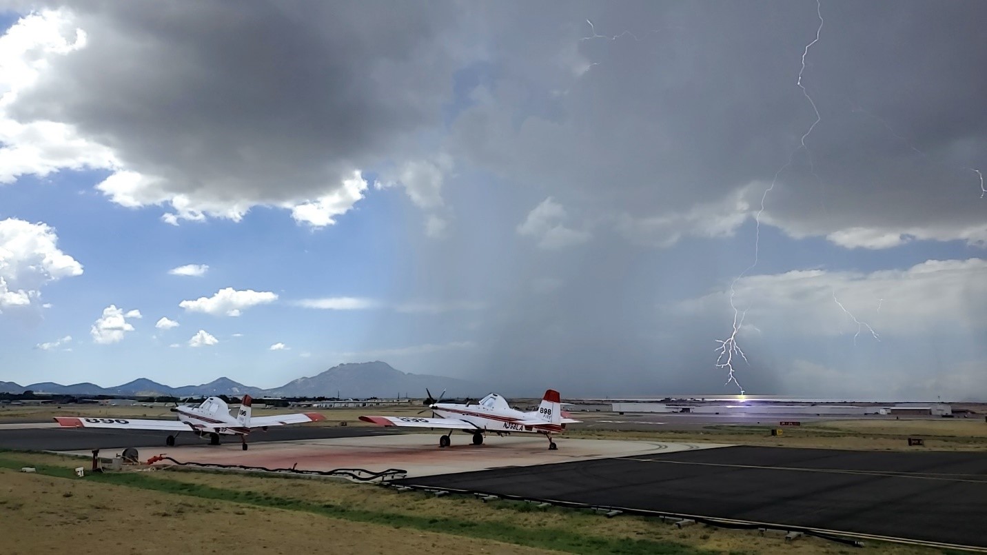 A single engine airtanker escorts an airtanker during a retardant drop.