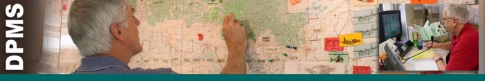 DPMS header graphic.  Photo of dispatcher reviewing large wall map with stickers identifying aircraft locations. Inset photo of dispatcher looking at computer screen with paperwork and microphone in front of him. Decorative.