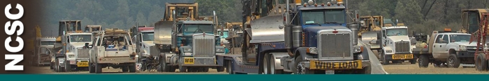 NCSC header graphic.  Photo of trucks loaded with heavy equipment lined up in dirt parking area. Decorative.