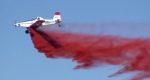 Side profile image of a single engine airtanker dropping retardant.