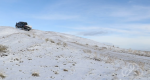 4WD truck climbing a snow covered hill.